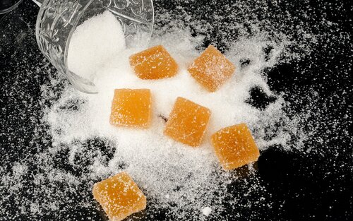 Розсипані по столу солодощі у цукрі | © Pexels