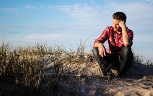 Засмучений хлопець сидить на піску | © Pexels